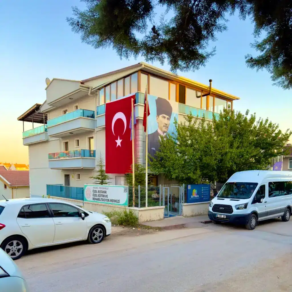 Botanik Özel Eğitim ve Rehabilitasyon Merkezi dış cephe görünümü, Türk bayrağı ve Atatürk posteri asılı modern eğitim binası – Yenimahalle Ankara.