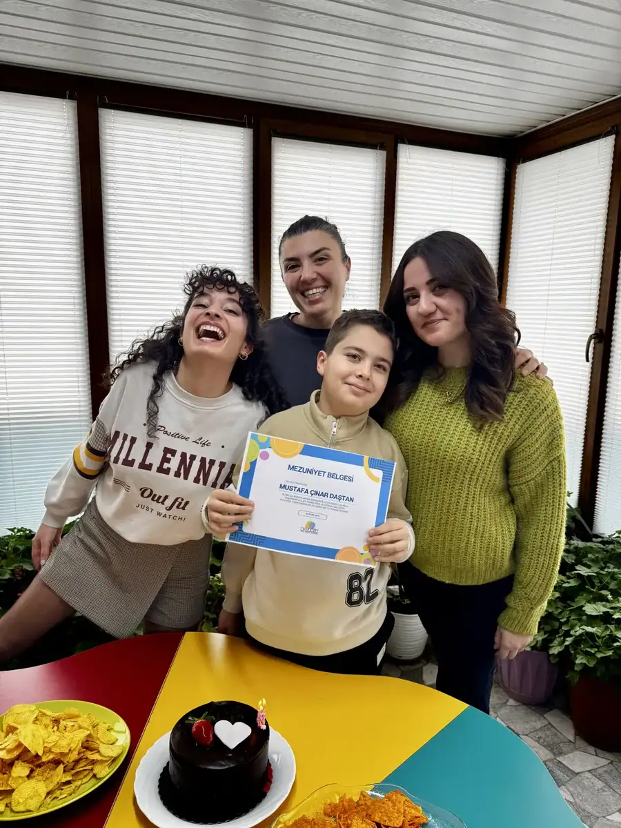 Mezuniyet belgesini öğretmenleriyle birlikte kutlayan mutlu öğrenci ve uzman kadrosu – Ankara Batıkent özel eğitim mezuniyet töreni.